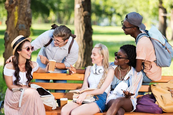 Estudantes multiétnicos no banco no parque — Fotografia de Stock