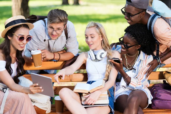Багатоетнічні студенти на лавці в парку — стокове фото