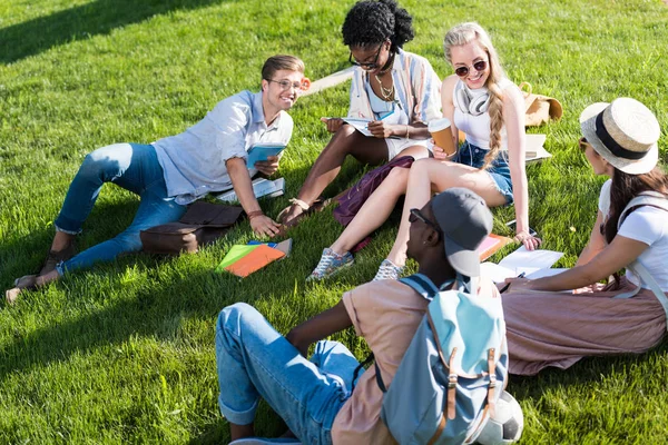 Багатоетнічні студенти відпочивають у парку — стокове фото