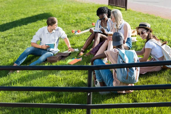 Мультиэтнические студенты отдыхают в парке — стоковое фото