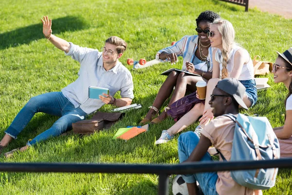 Estudiantes multiétnicos descansando en el parque - foto de stock