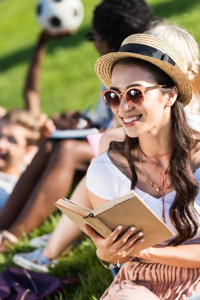 Chica leyendo libro en el parque - foto de stock