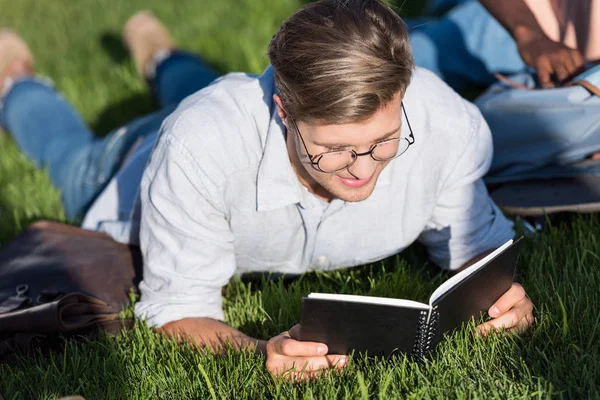 Mann liest Lehrbuch im Park — Stockfoto