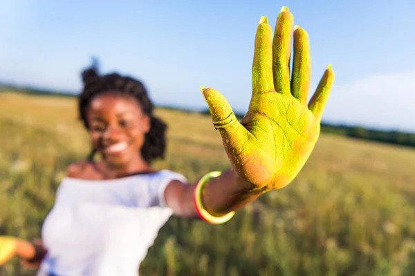 Girl with yellow paint on palm — Stock Photo