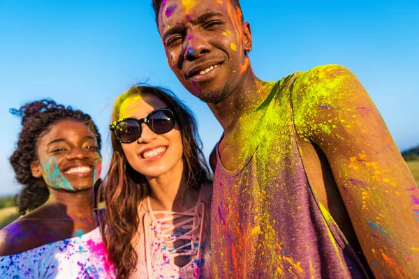 Amigos felices en el festival de colores - foto de stock