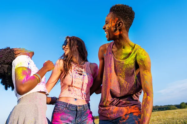 Amigos felices en el festival de colores - foto de stock