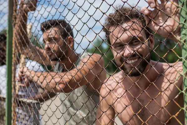 Men leaning on fence — Stock Photo