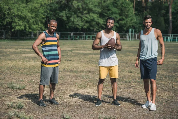 Hommes multiculturels jouant au football — Photo de stock