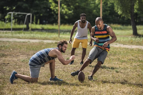 Hommes multiculturels jouant au football — Photo de stock