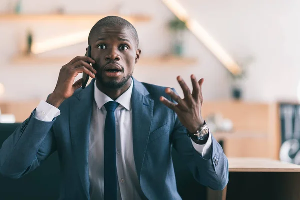 Scioccato uomo d'affari parlando su smartphone — Foto stock