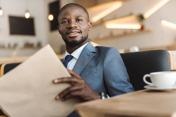 Hombre de negocios menú de lectura en la cafetería - foto de stock