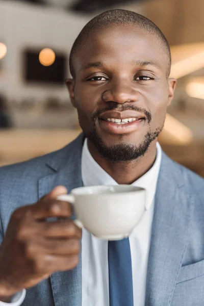Бизнесмен с чашкой кофе в кафе — стоковое фото