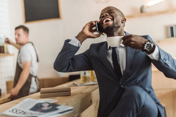 Счастливый бизнесмен разговаривает на смартфоне — стоковое фото