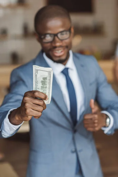 Hombre de negocios con dinero y pulgar hacia arriba - foto de stock