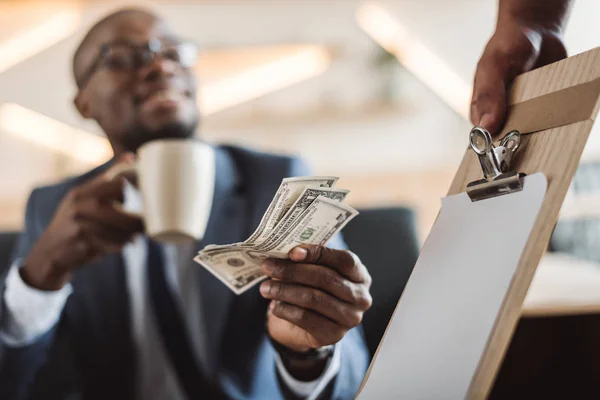Man paying with cash  in cafe — Stock Photo
