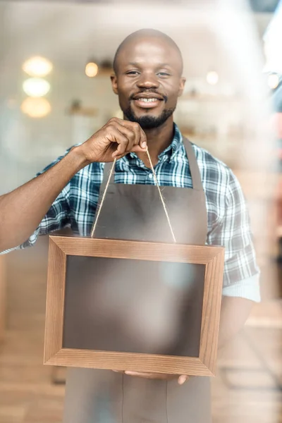 Owner holding empty blackboard — Stock Photo