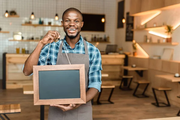 Owner holding empty blackboard — Stock Photo