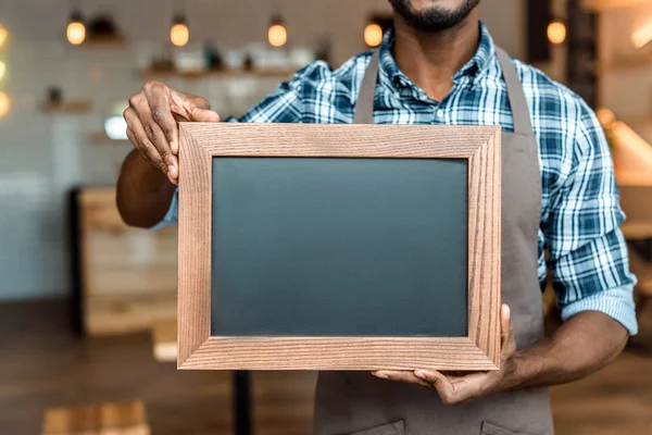 Owner holding empty blackboard — Stock Photo