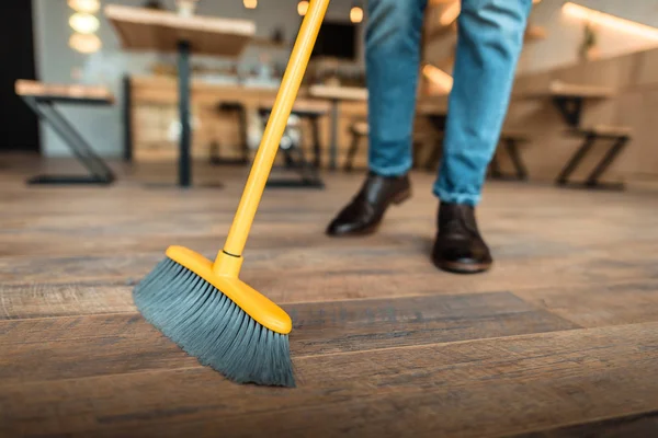 Man brooming in coffee shop — Stock Photo