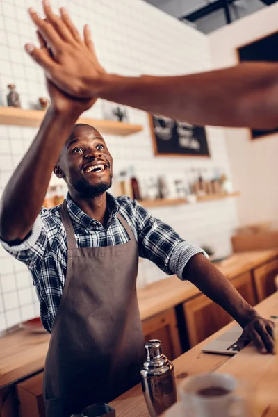 Barista giving highfive to client — Stock Photo