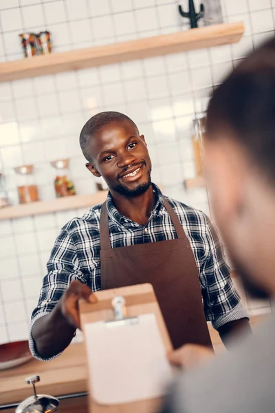 Barista giving menu to client — Stock Photo