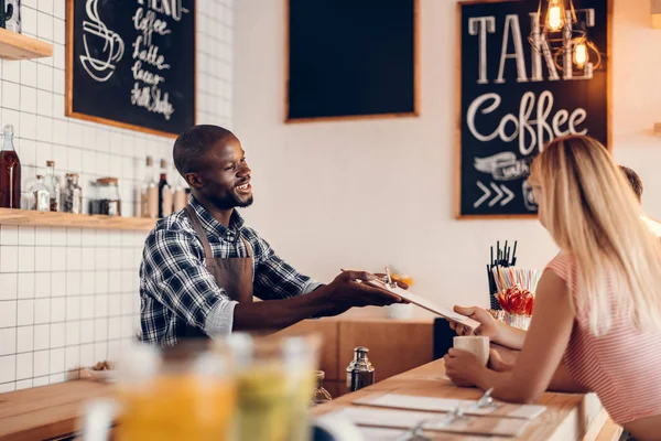 Barista dando menú a los clientes - foto de stock