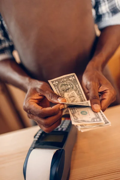 Barista con terminal contando dinero — Stock Photo