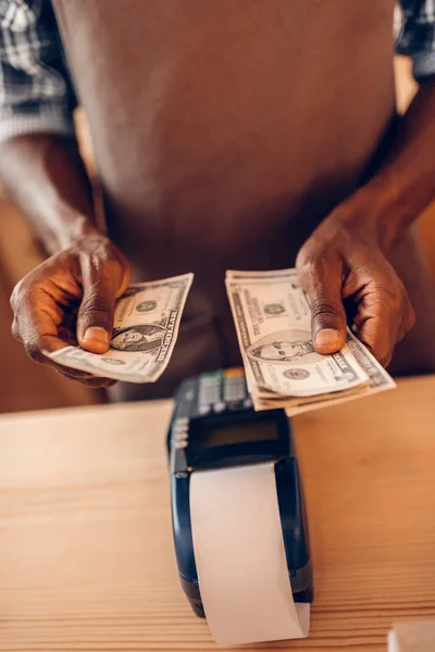 Barista with terminal counting money — Stock Photo