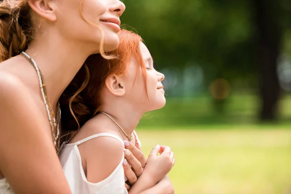 Madre e hija abrazándose en el parque - foto de stock