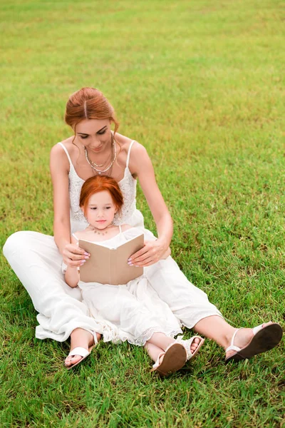 Мати і дочка з книгою в парку — стокове фото