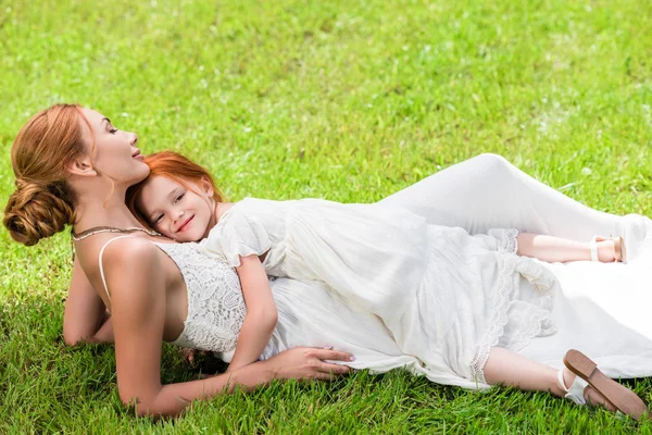 Madre e hija abrazándose en el parque - foto de stock