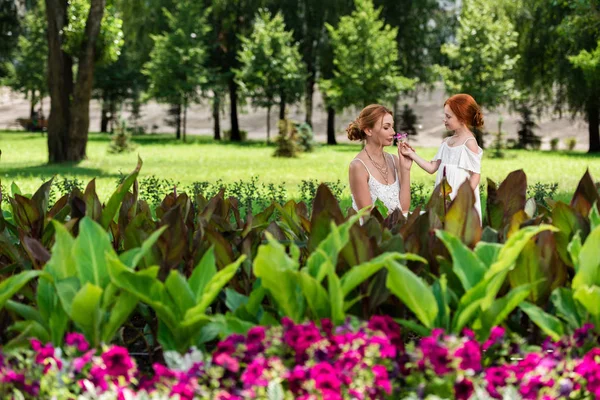 Madre e hija cerca del macizo de flores - foto de stock