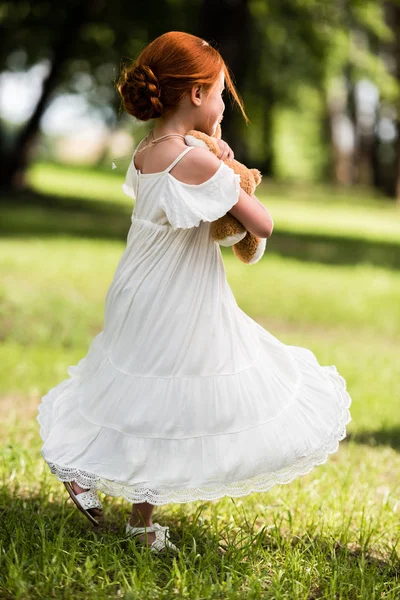 Menina com ursinho de pelúcia no parque — Fotografia de Stock