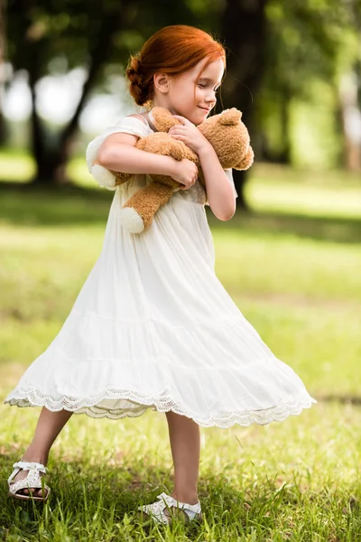 Menina com ursinho de pelúcia no parque — Fotografia de Stock
