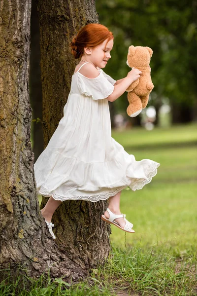 Menina com ursinho de pelúcia no parque — Fotografia de Stock