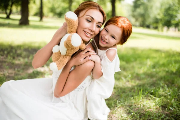 Mãe e filha com ursinho de pelúcia no parque — Fotografia de Stock