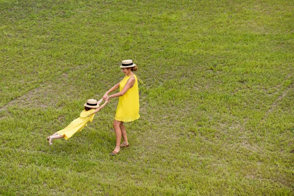 Madre e hija caminando sobre el césped - foto de stock