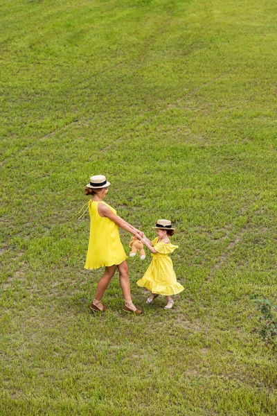 Madre e hija caminando sobre el césped - foto de stock