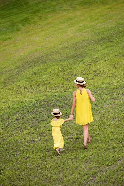 Madre e hija caminando sobre el césped - foto de stock