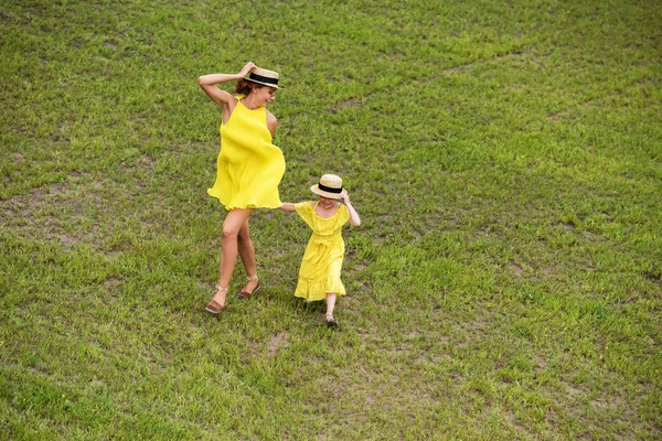 Мать и дочь идут по газону — стоковое фото