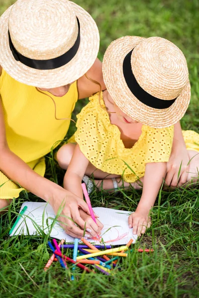 Madre e hija dibujando en el parque - foto de stock