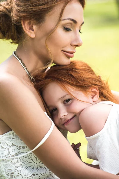 Madre e hija abrazándose en el parque - foto de stock