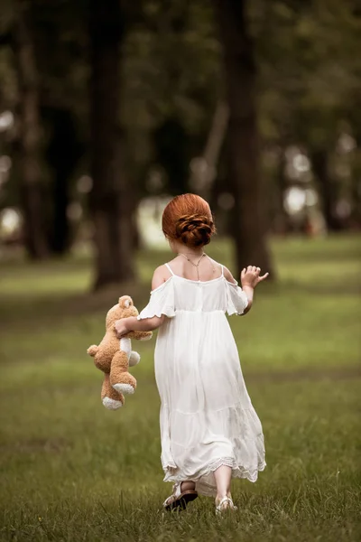 Redhead girl with teddy bear — Stock Photo
