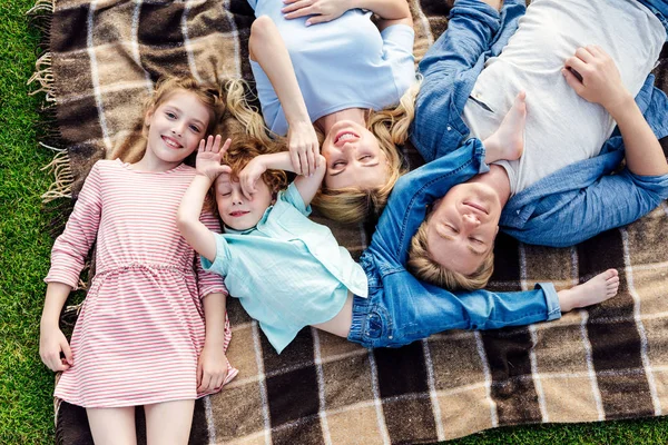 Familia feliz acostada sobre cuadros - foto de stock