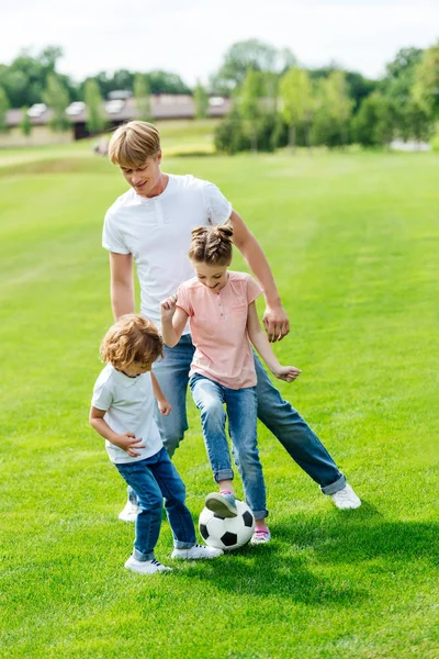 Батько з дітьми грає у футбол — стокове фото