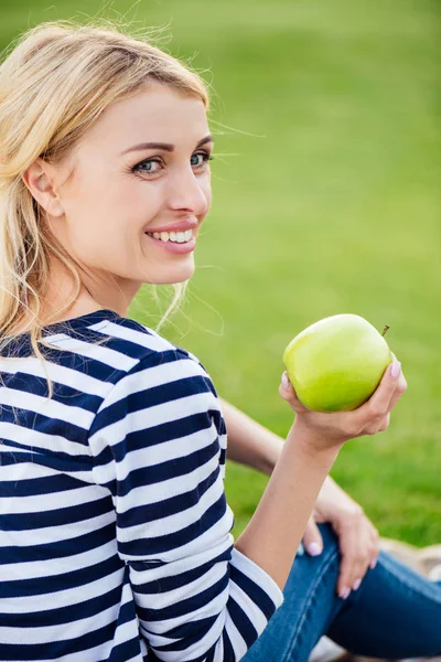 Mujer con manzana en el parque - foto de stock