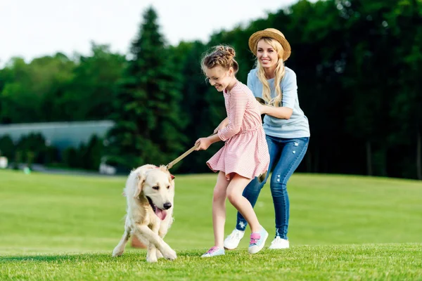 Madre e figlia con cane nel parco — Foto stock