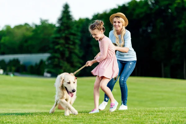 Mãe e filha com cão no parque — Fotografia de Stock