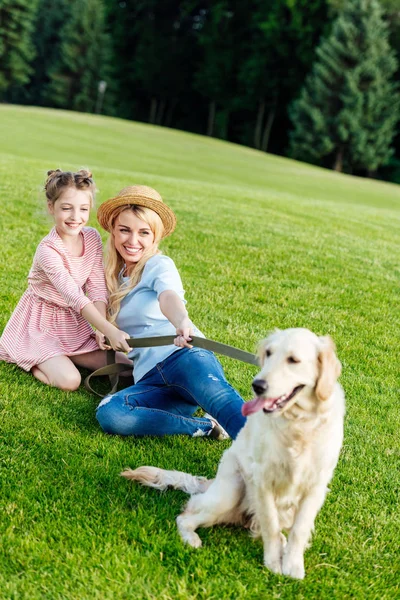 Madre e figlia con cane nel parco — Foto stock