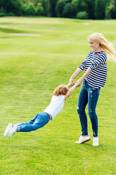 Madre feliz con su hijo en el parque - foto de stock